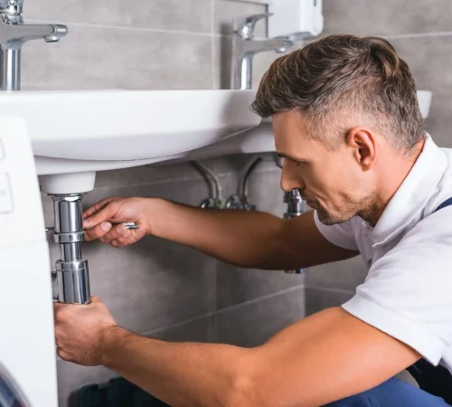 adult-plumber-fixing-sink-at-bathroom